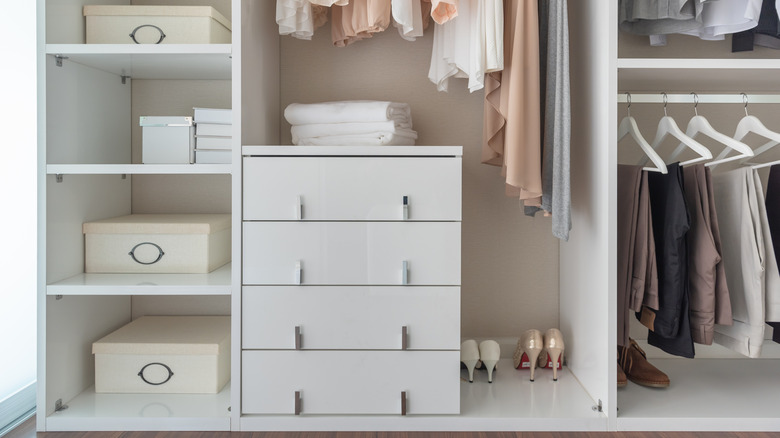 Organized closet with a white dresser beside a set of cubby shelves.