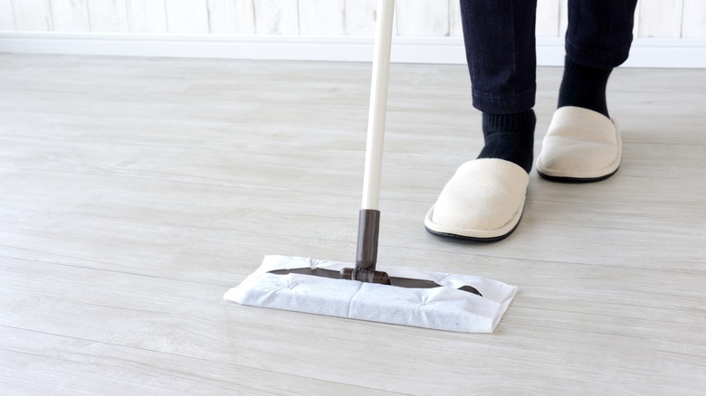 person in slippers mopping floor