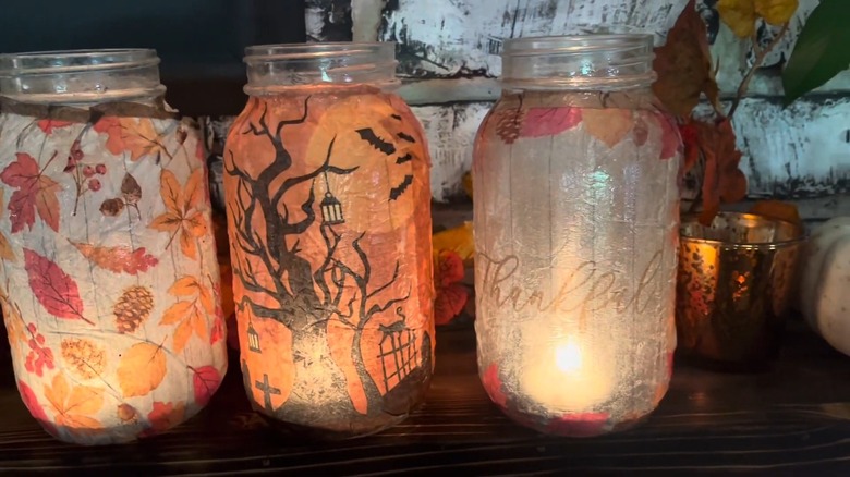 Three napkin-covered mason jar lanterns on a table