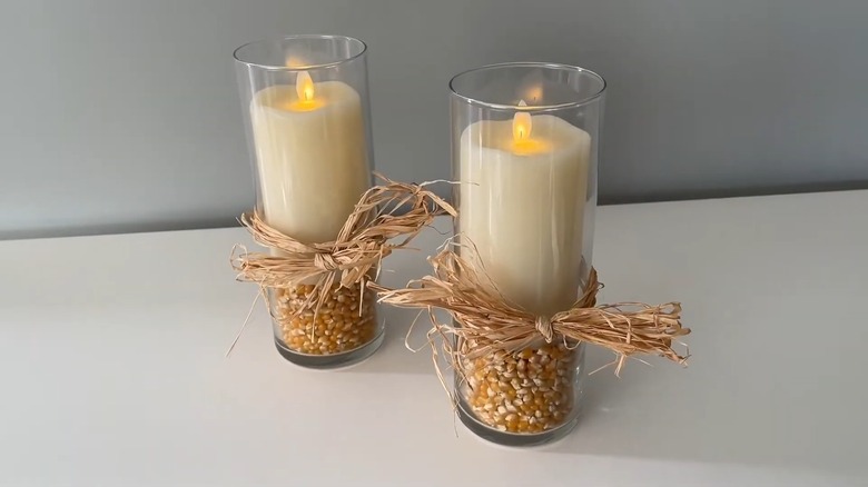 Two glass vases with corn and LED candles inside