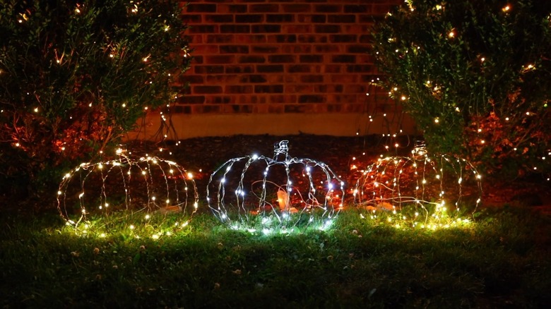 Glowing pumpkin wreath forms in yard