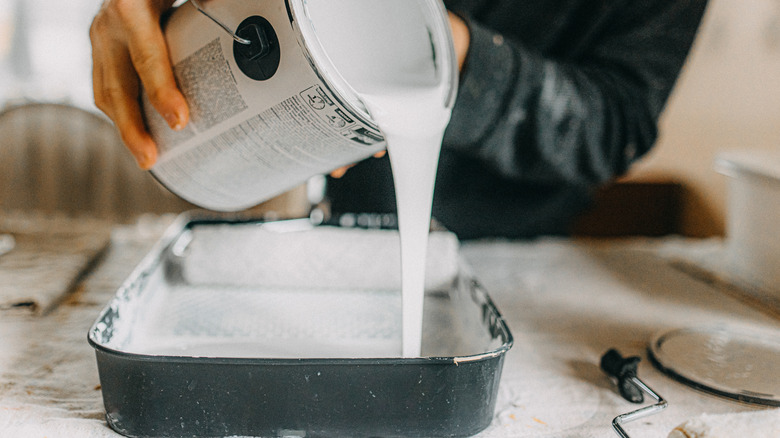 close up of someone pouring white paint