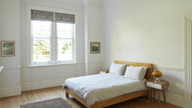 White, neutral, and green bedroom with double window and no visible closets