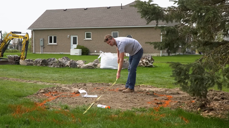a man measuring where his hot spring is going to go
