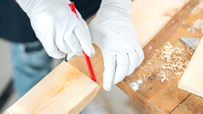 man marking 2x4 cut line
