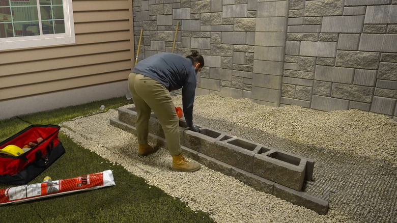 a man installs geogrid in a retaining wall
