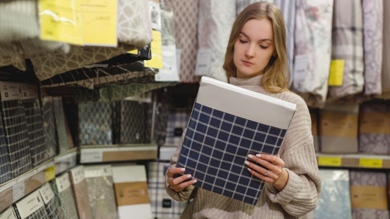 Woman holding a package of bed sheets for sale