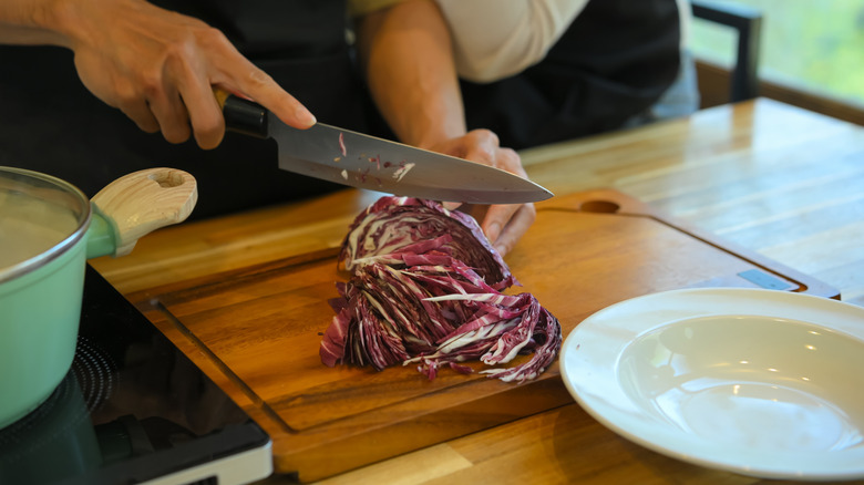 A person chopping red cabbage