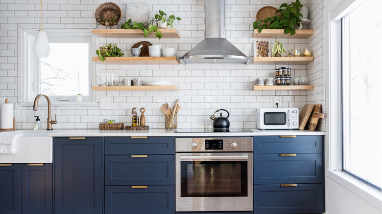 A kitchen with blue cabinets and brass hardware
