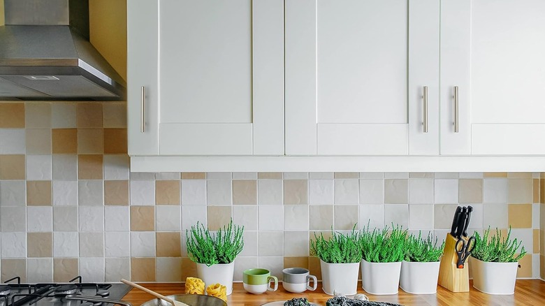 A ktichen with white cabinets and brushed nickel pulls