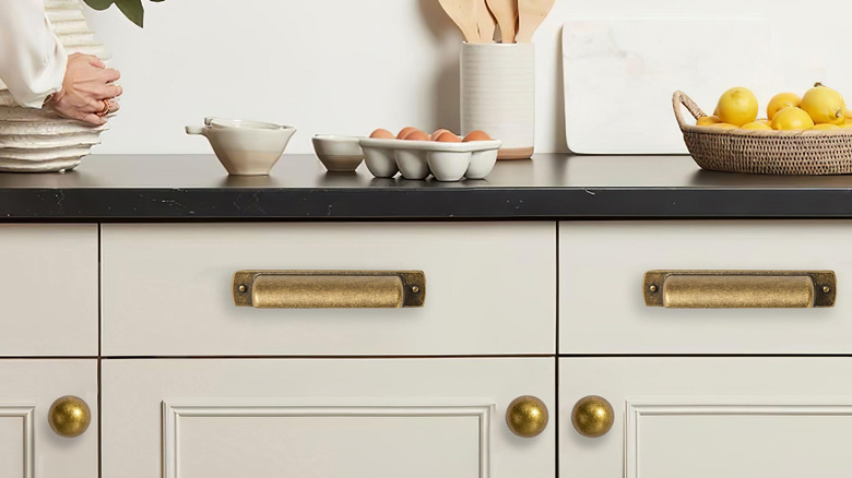 White kitchen cabinets with aged brass pulls and knobs
