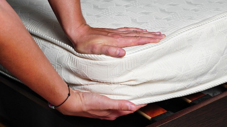 Close up of hand under mattress