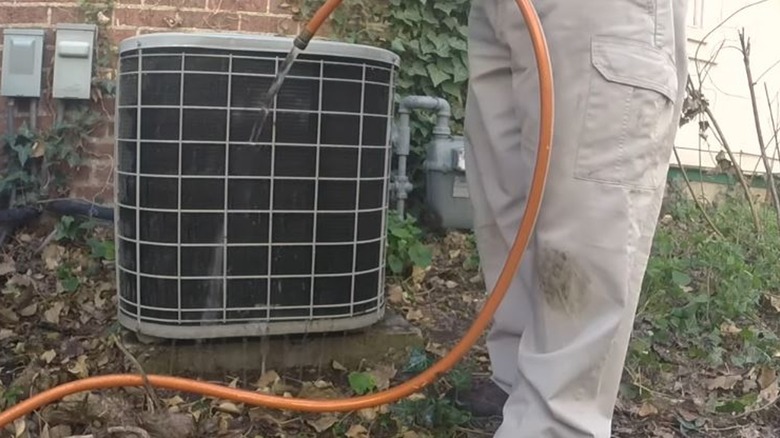 Man rinsing condenser unit