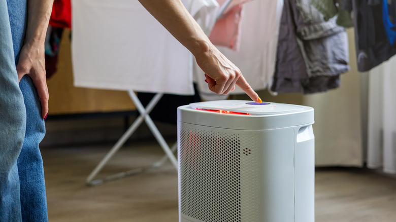 a woman setting up a dehumidifier indoors