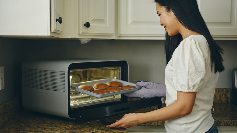 woman baking cookies in countertop oven