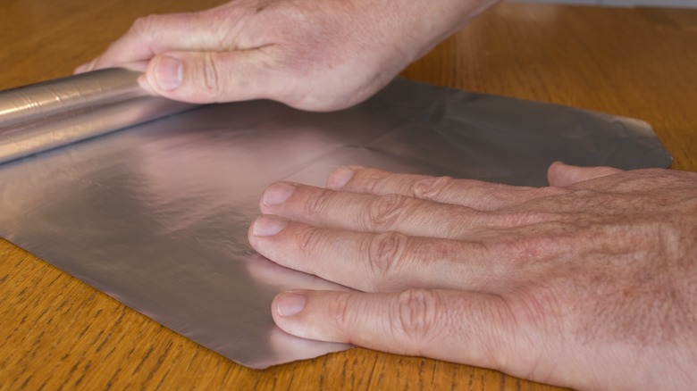 hands unroll Aluminum foil