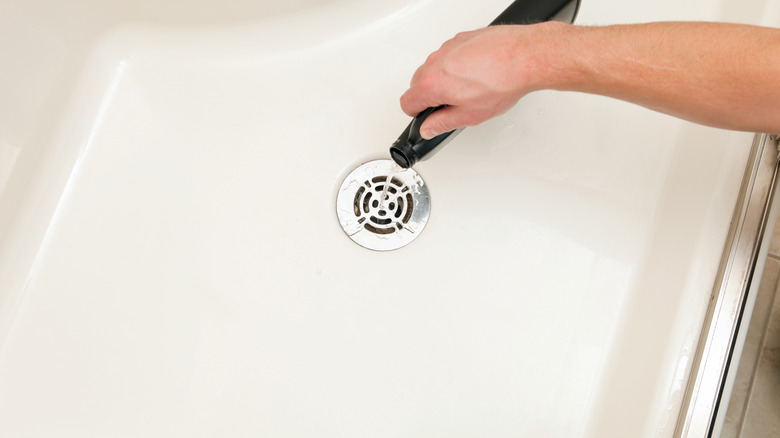 Person pouring bottle of drain cleaner