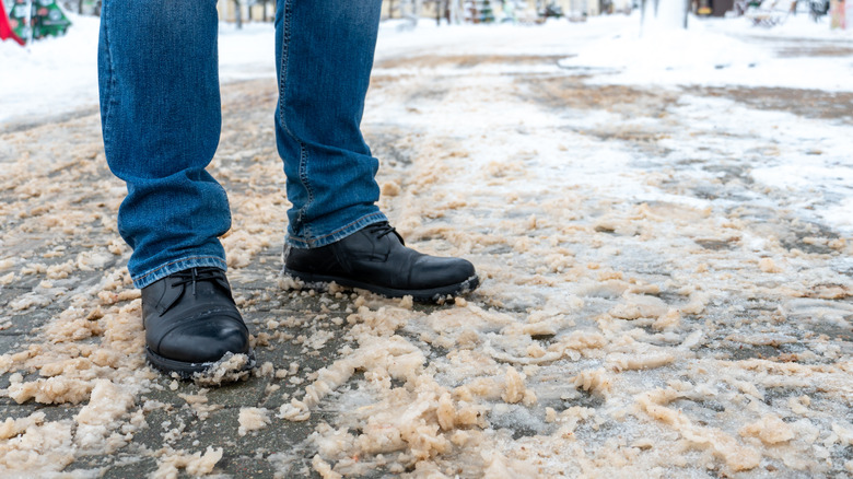 Man standing on slushy pavement