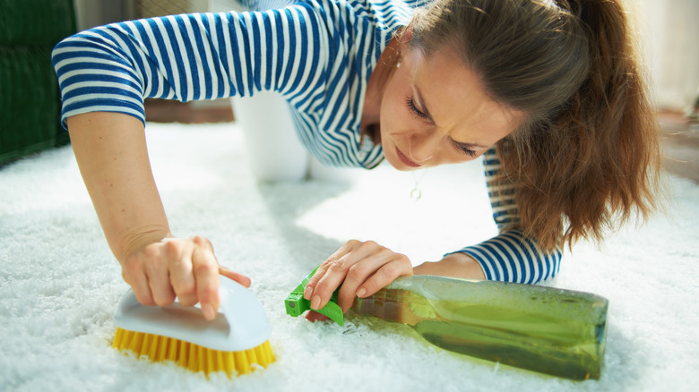 Woman scrubs stain on carpet