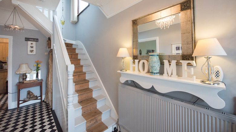 a radiator sitting beneath a shelf located close to the stairs