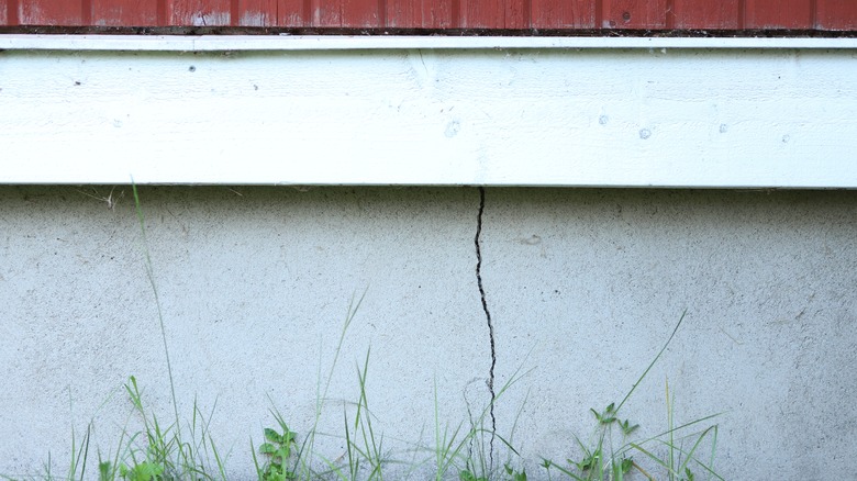 A visible crack running along the foundation of a house