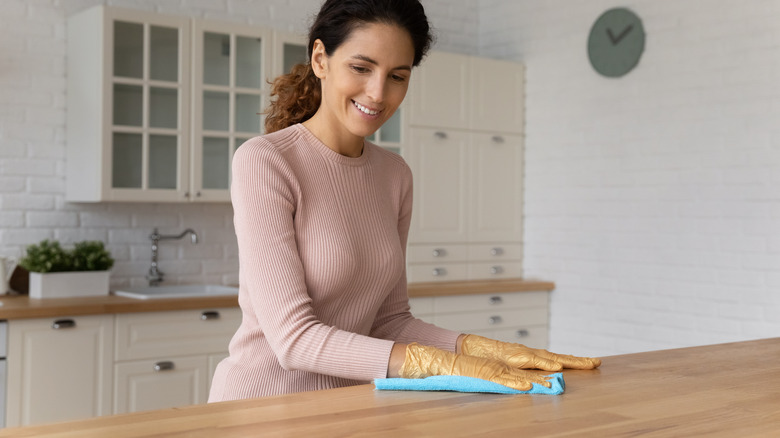 Woman wiping down wooden table