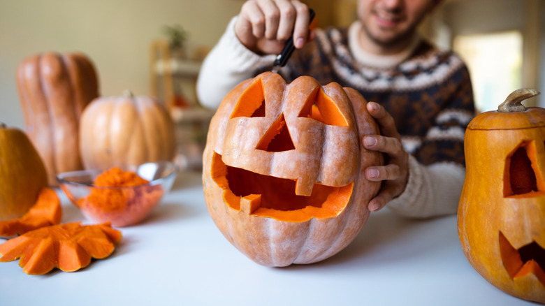 Child carving pumpkin