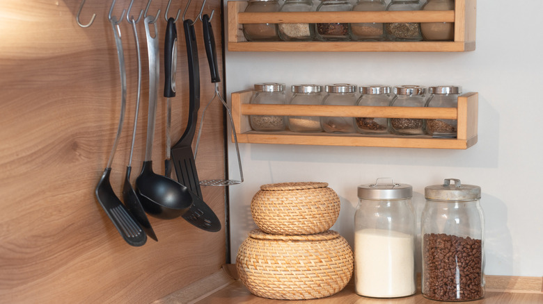 an orderly kitchen storage setup using hooks and wall-mounted shelving