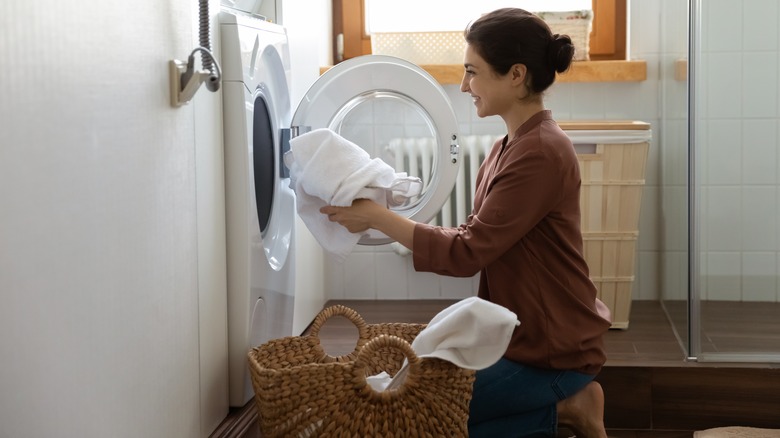 Woman loading clothes into washer