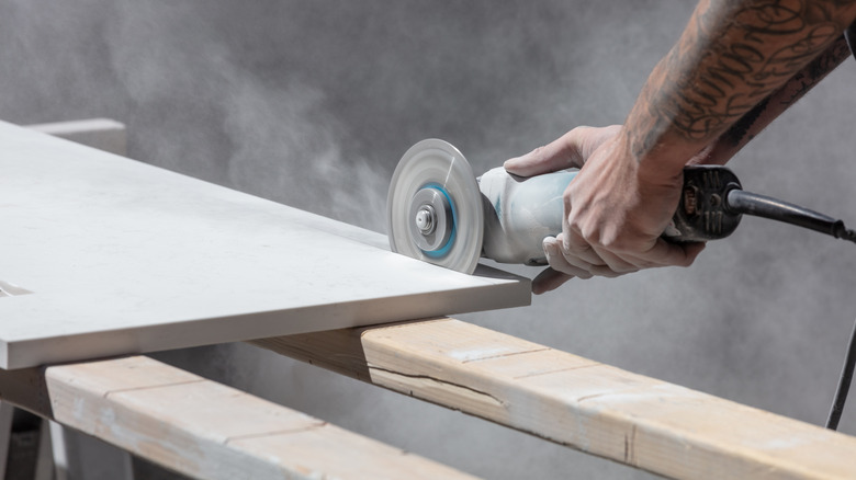 Man cutting kitchen countertop with saw