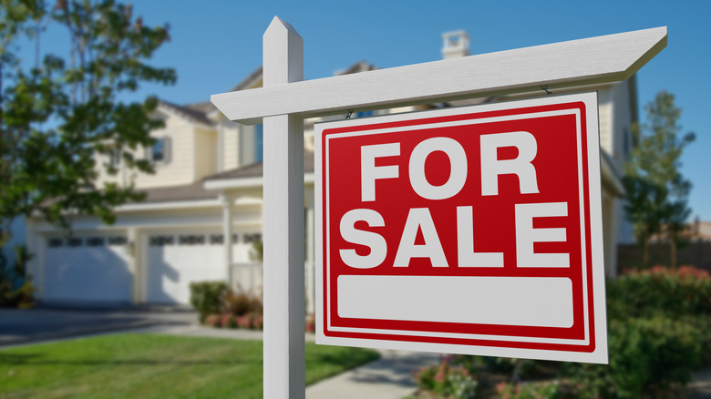 Red "for sale" sign in front of house
