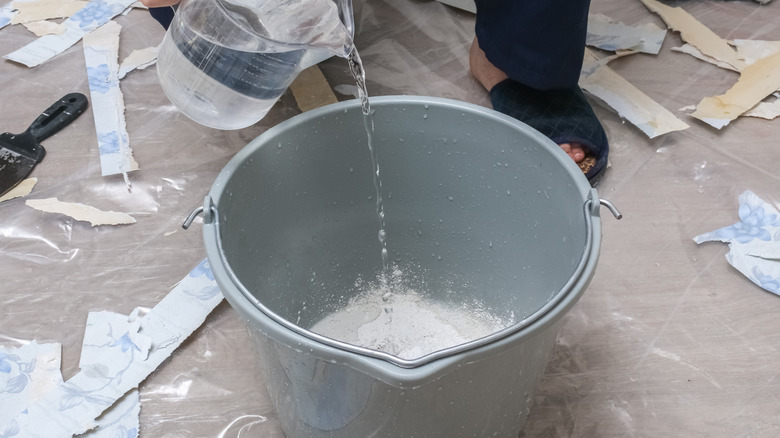 water and plaster being mixed in a gray bucket