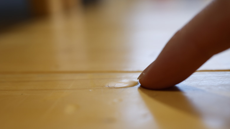 Finger pointing out dent in vinyl floor