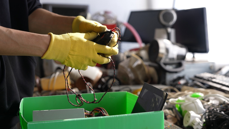 Gloved hands sorting through electronics components