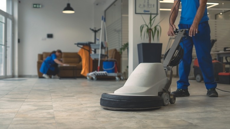 Worker buffing tiled floor