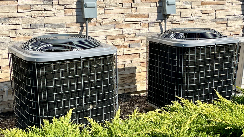 Two exterior air conditioning units near a house