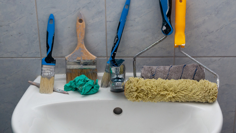 Paint tools propped up on bathroom sink