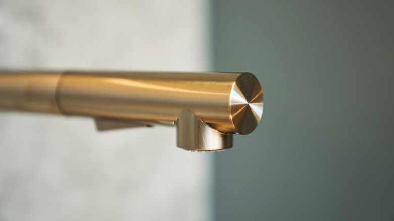 Close-up of a modern kitchen faucet made of brushed brass.