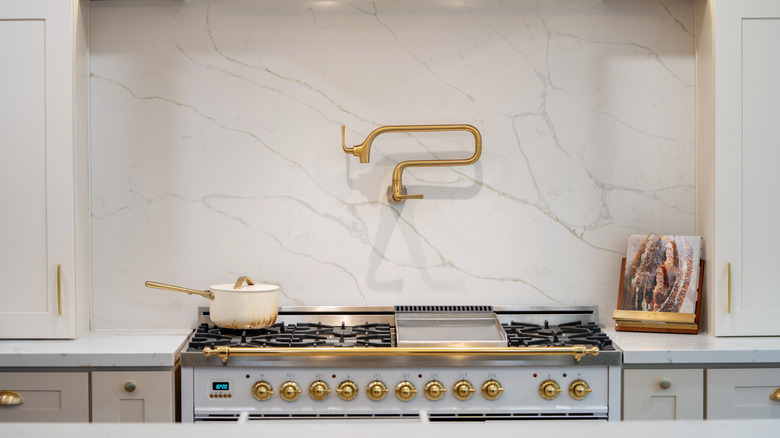 a pot filler faucet on a kitchen wall above a stove