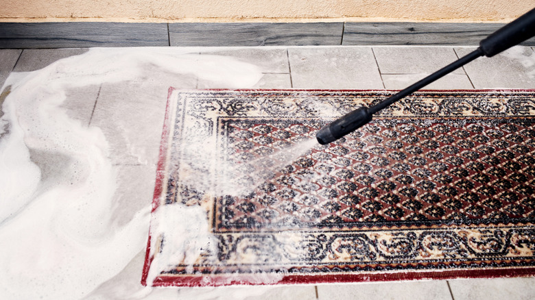 Cleaning a multicolored rug with a pressure washer
