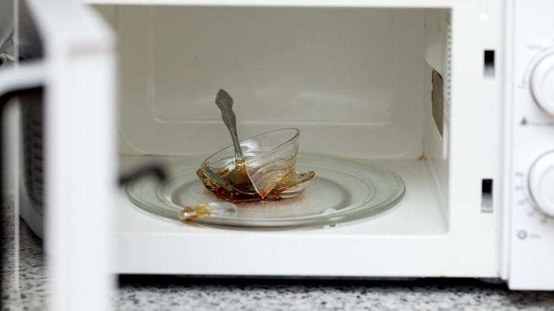 A broken glass bowl sitting inside of a microwave