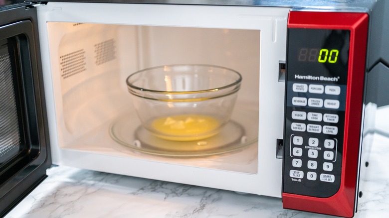 Melted butter inside a glass bowl being heated up in a microwave