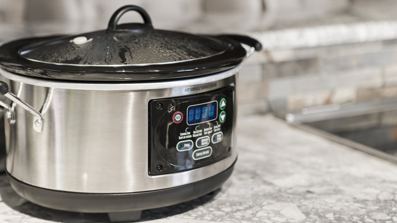 Food cooking in a slow cooker on a kitchen counter