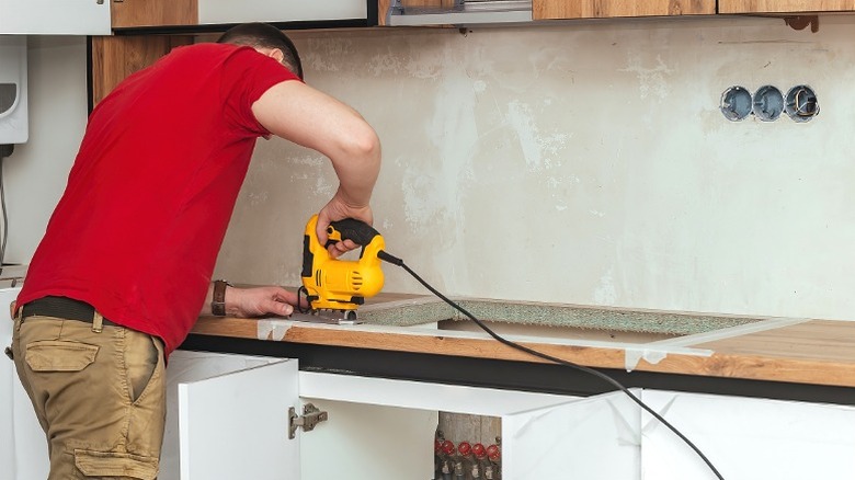Man cutting a kitchen sink opening with a jigsaw