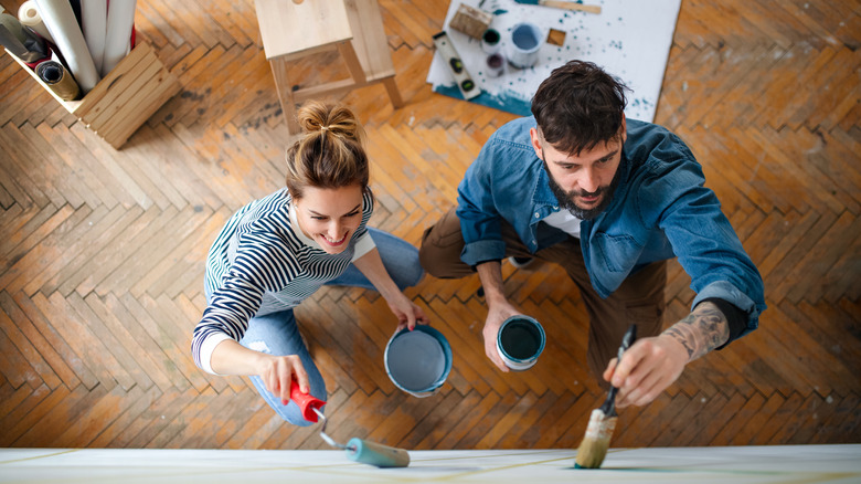 A couple painting a wall