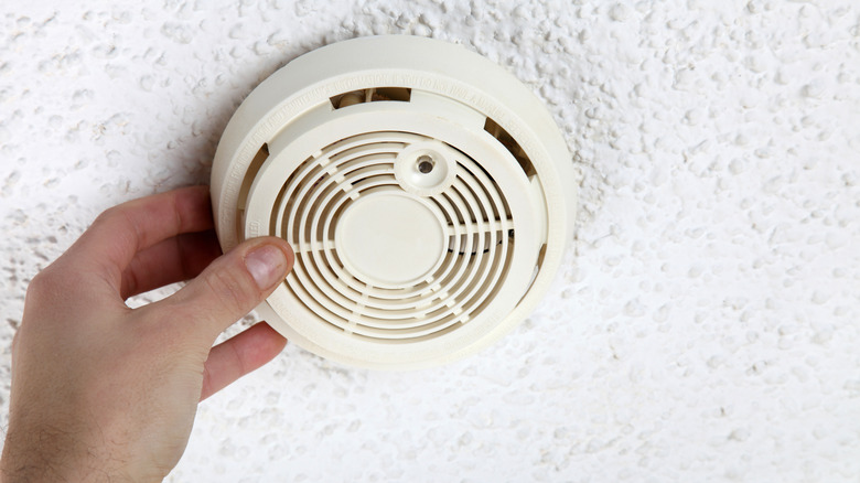 Person installing a smoke detector