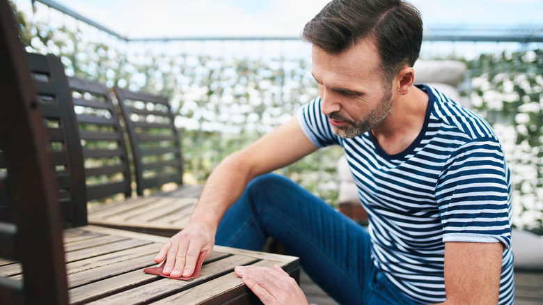 Man cleaning patio furniture