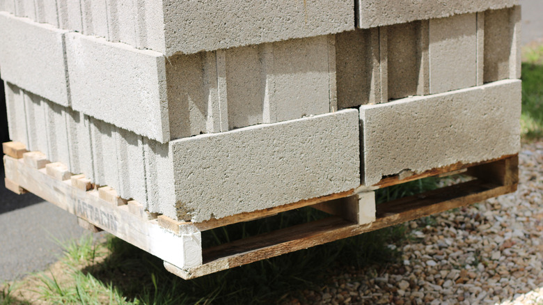 A pallet of concrete blocks near a curb