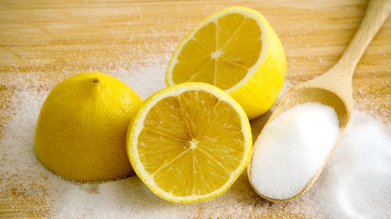 three lemon halves next to an overflowing spoonful of salt