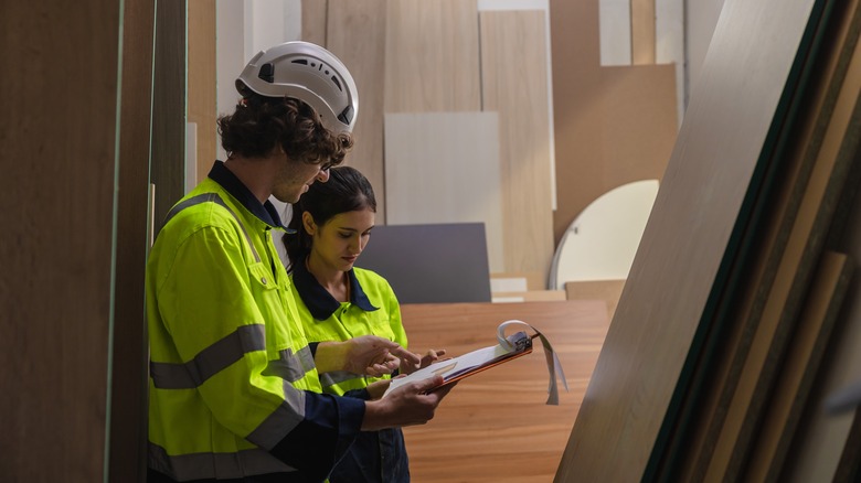 warehouse workers examining wood varieties